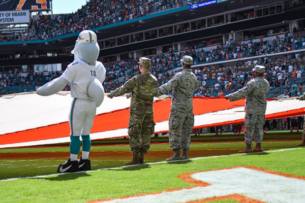 TD and soldiers from the Armed Forces hold the flag during the National Anthem