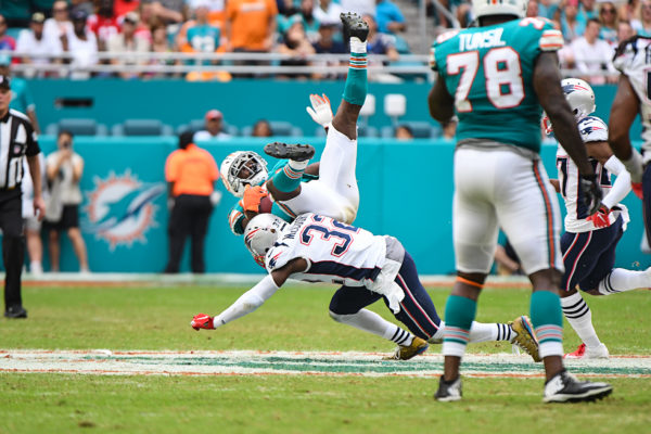 New England Patriots free safety Devin McCourty (32) tackles Miami Dolphins running back Frank Gore (21)