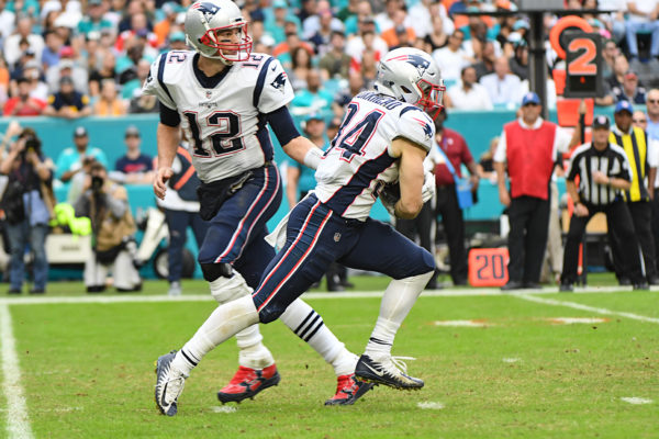 New England Patriots quarterback Tom Brady (12) hands off to New England Patriots running back Rex Burkhead (34)