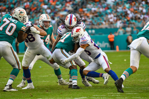 Miami Dolphins running back Frank Gore (21) is tackled by Buffalo Bills middle linebacker Tremaine Edmunds (49) and Buffalo Bills strong safety Micah Hyde (23)