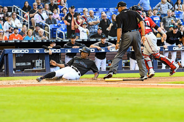 Miami Marlins left fielder Curtis Granderson #21 slides across home plate