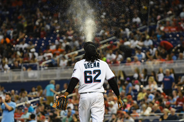 Miami Marlins starting pitcher Jose Urena (62) spits water into the air as he walks to the mound