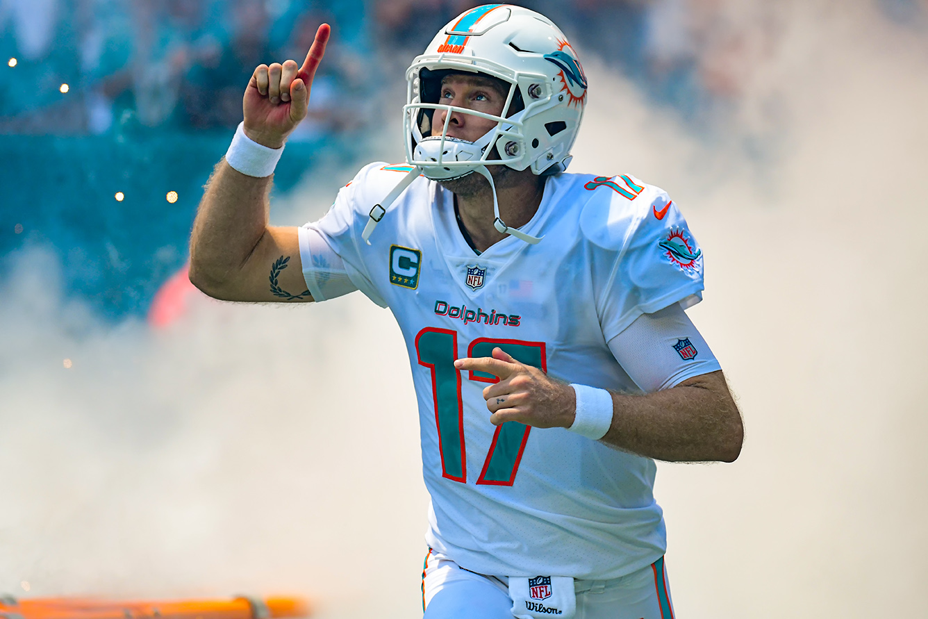 Miami Dolphins quarterback Ryan Tannehill (17) points to the sky as he runs through the smoke